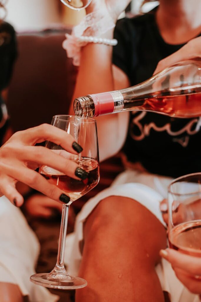 Crop anonymous ladies drinking wine during hen party